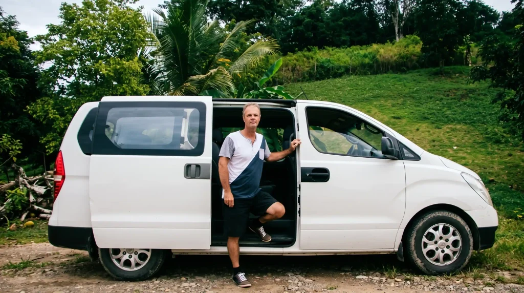 Ron standing beside a shuttle vehicle used by Ron’s Belize Shuttles in Belize